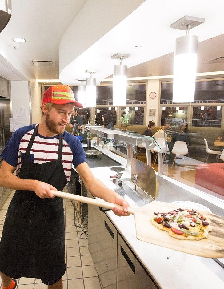 a student worker prepares a pizza a the shakedown cafe